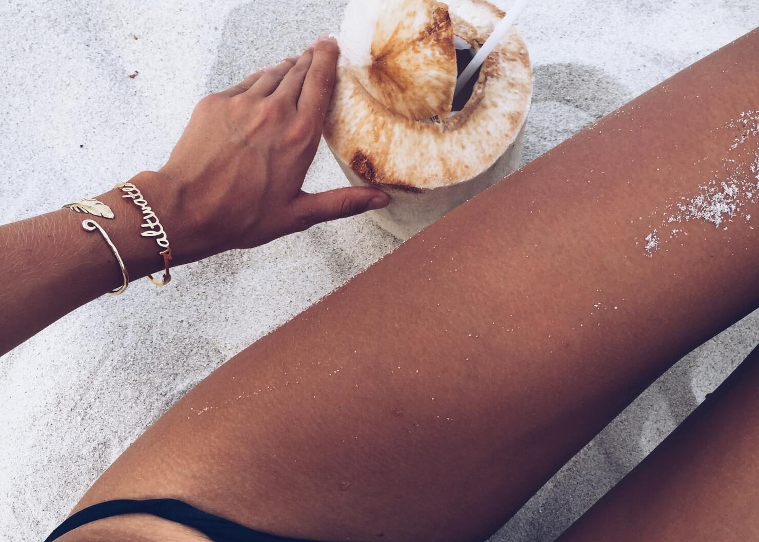 tan girl with coconut at beach