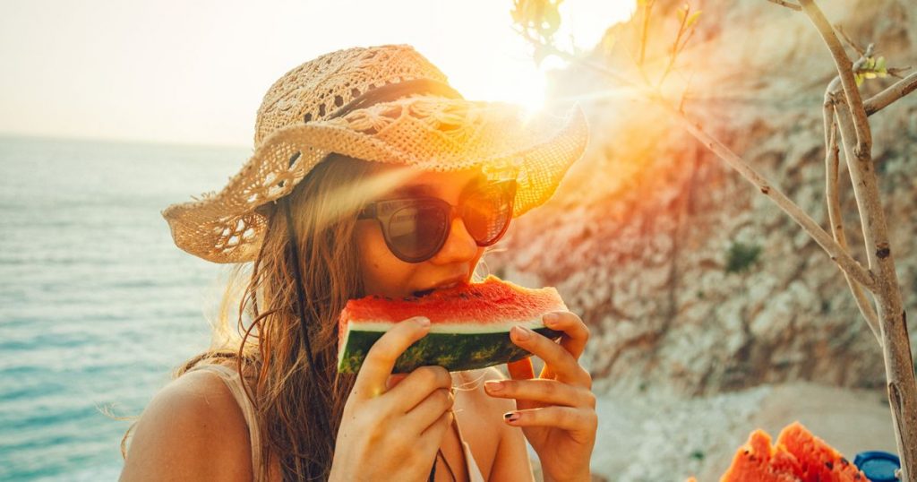 Girl eating watermelon during sunrise