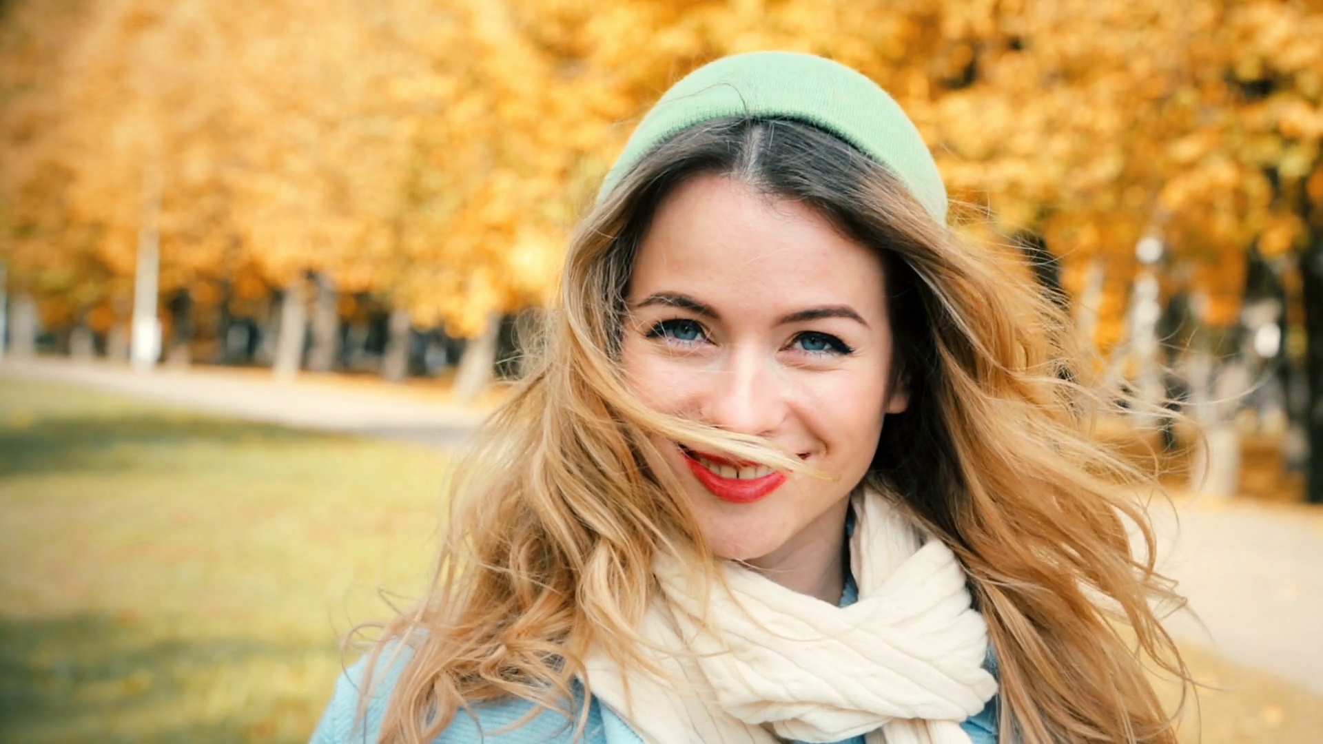girl in front of autumnal background with hair infront of face