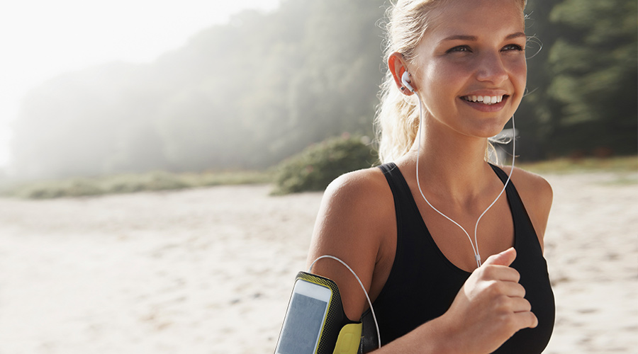 girl running on beach listening to music