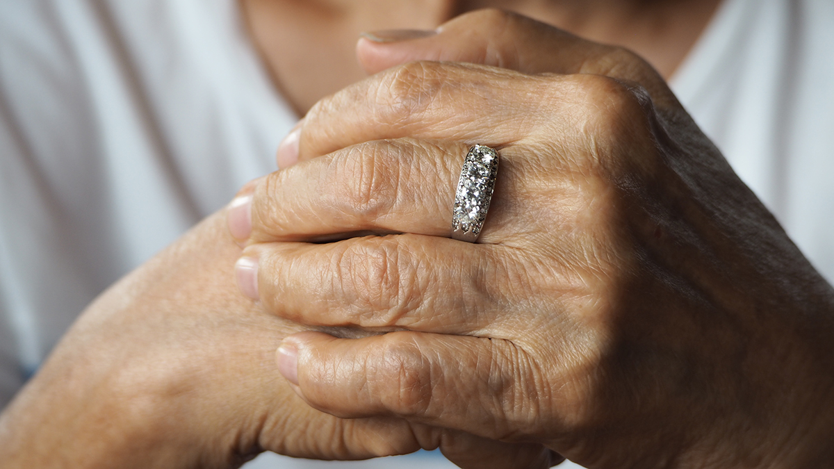 Closeup of an aging woman's hands with a diamond ring