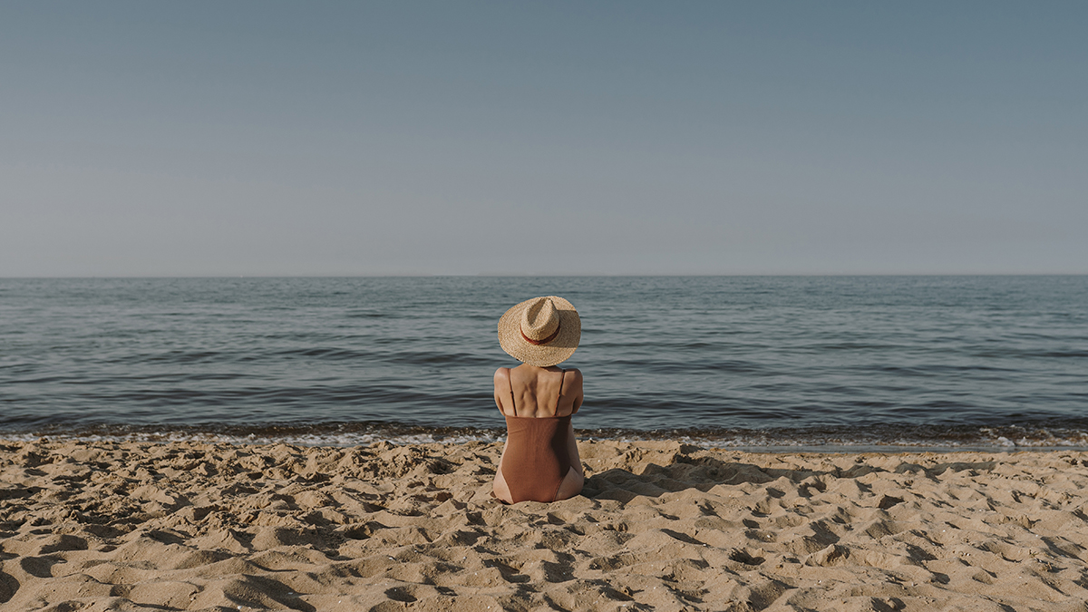 Woman with straw hat on the beach