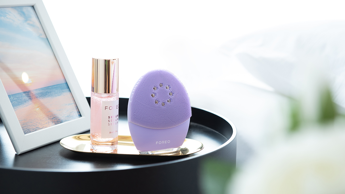 FOREO LUNA 4 on a nightstand with FOREO SUPERCHARGED serum