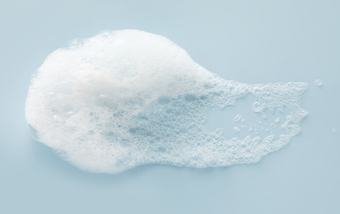 Smear of white foam on light blue surface