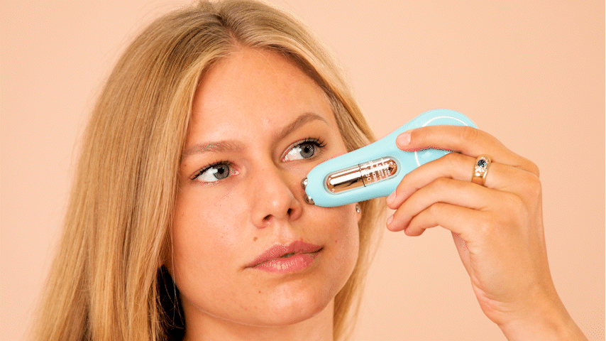 A blonde female model gliding a microcurrent device FOREO BEAR 2 eyes&lips under her eye