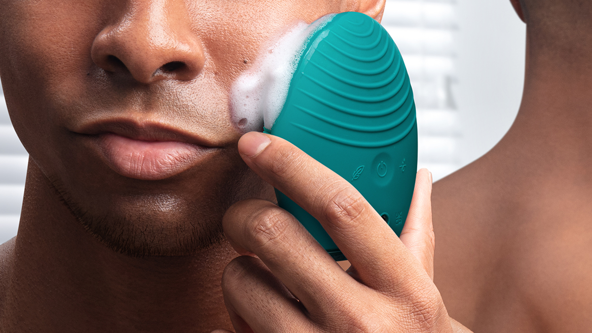 A male model closeup, using FOREO LUNA 4 men facial cleansing brush to cleanse his face